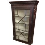 A nineteenth century mahogany corner cabinet with moulded dentil cornice above an astragal glazed