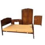 A four-piece walnut bedroom suite by The West of Scotland Furniture Company, with dressing table,