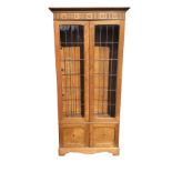 An Edwardian glazed bookcase, with moulded cornice above a fluted roundel carved frieze, the