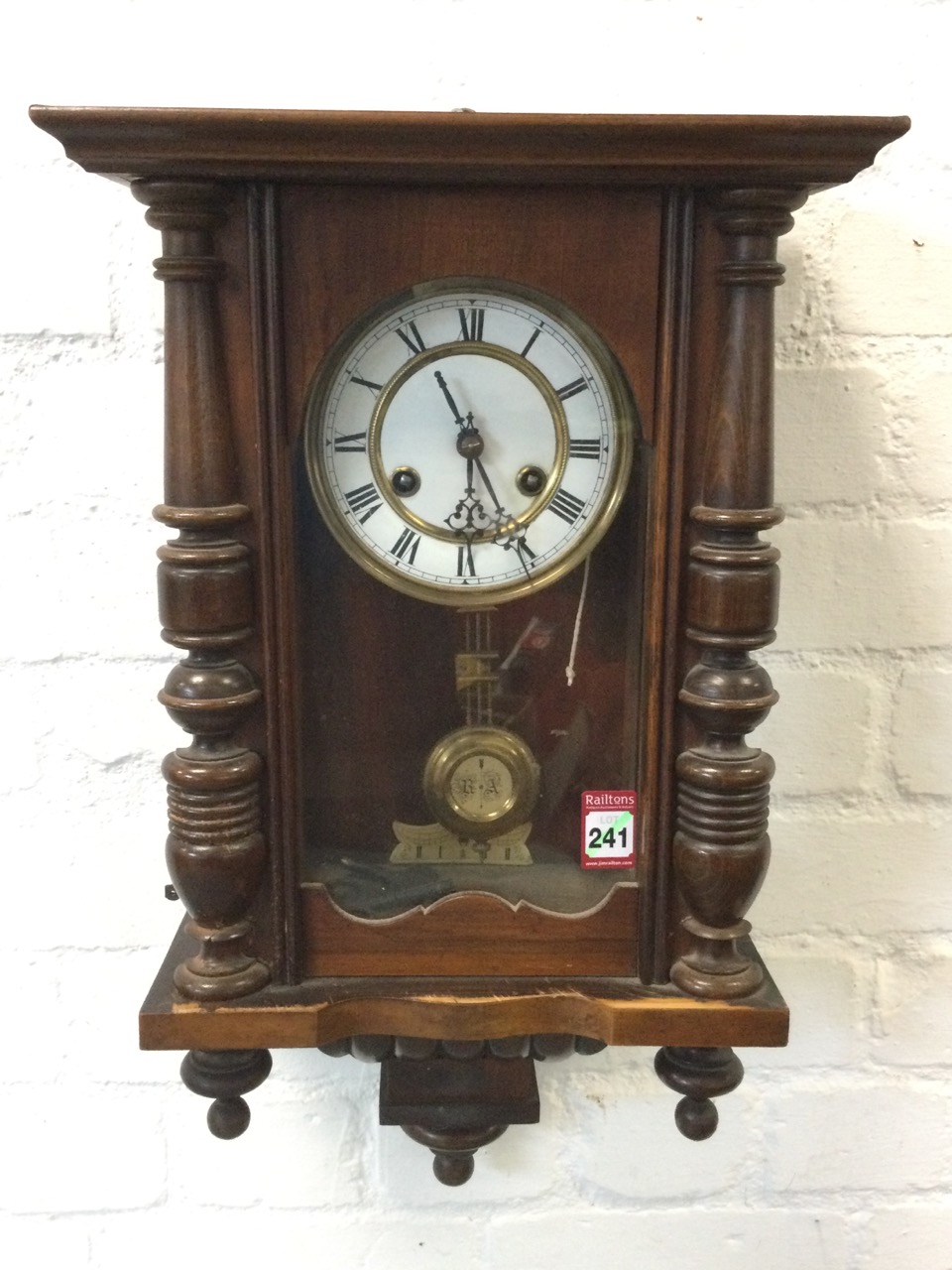 A late Victorian walnut cased Vienna wallclock, with moulded cornice above an arched door flanked by