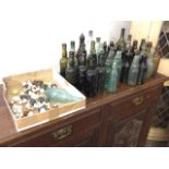 A collection of 42 antique green, brown & clear glass bottles from Border breweries - Stoddart of
