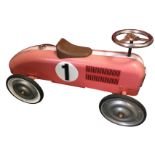 A childs tin racing car with chrome steering wheel and ribbed tyres. (29in)