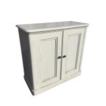 A painted Victorian cupboard with moulded top above panelled doors enclosing shelves, raised on