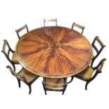 A circular regency style mahogany dining table with eight chairs, the rosewood crossbanded segmented