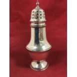 A hallmarked silver caster, the pierced domed lid with finial above a pear shaped body, with