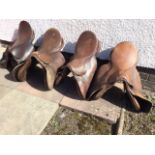 Four brown leather saddles. (4)