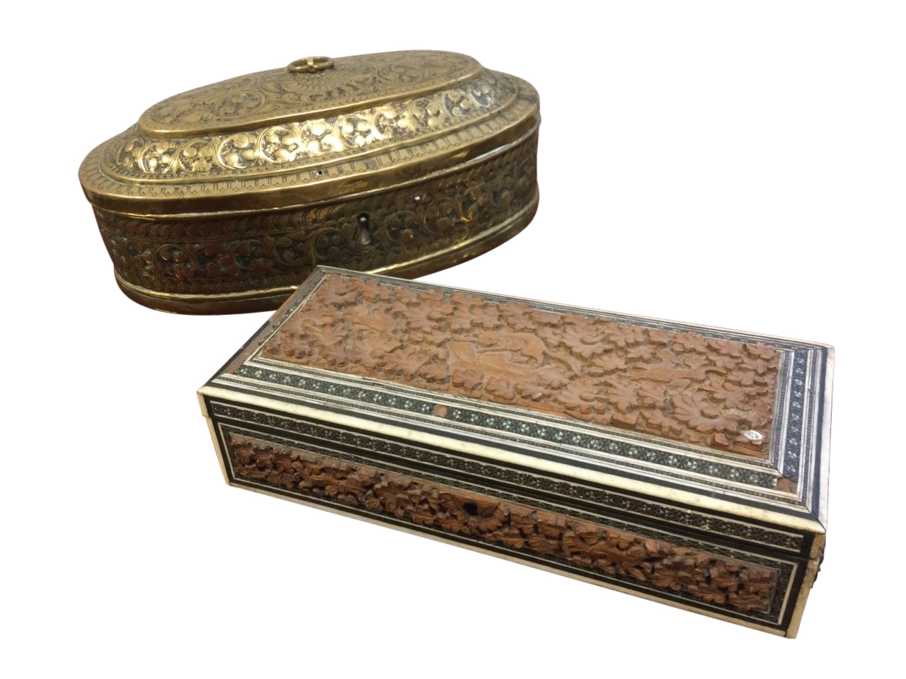 An oval nineteenth century brass box embossed with foliate scrolled decoration, with punched