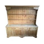 A pine dresser, the delft rack with moulded dentil cornice above a pierced fretwork apron, having
