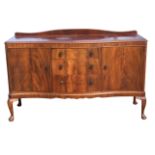 A serpentine fronted mahogany sideboard, with shaped upstand above moulded top, having three central
