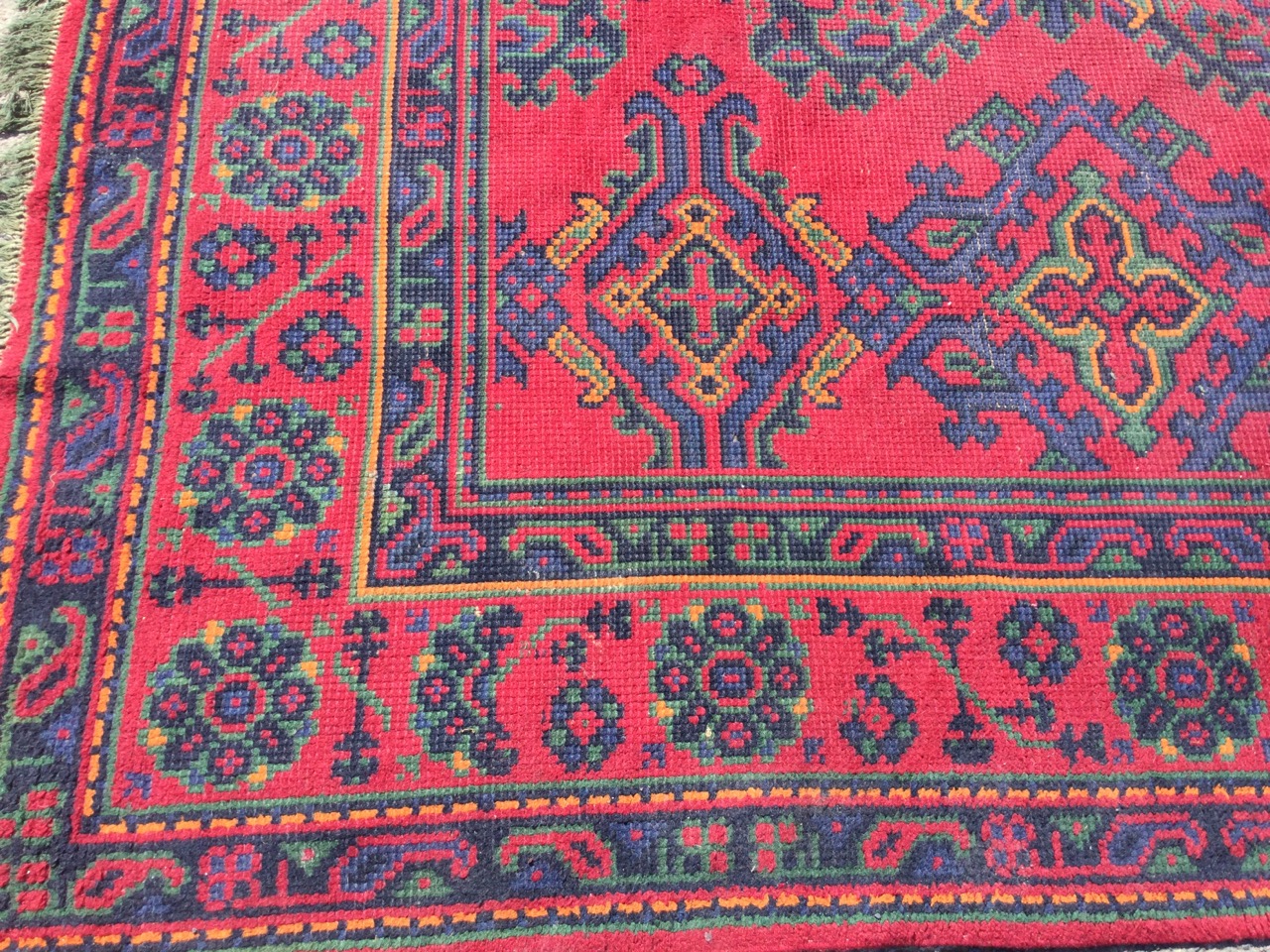 A square Turkey carpet woven in the traditional palette on red ground, the field with rows of - Image 2 of 3