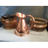 A hammered copper harvest jug with tubular handle; an oval Victorian helmet shaped copper coal