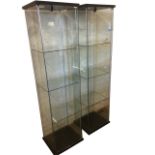 A pair of contemporary glazed display cabinets, each with three glass shelves having hinged