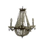 A French style empire chandelier with brass leaf coronet suspending graduating glass button swags,