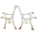 A pair of cast iron bench ends with scrolled decoration to channelled frames, the arms cast with