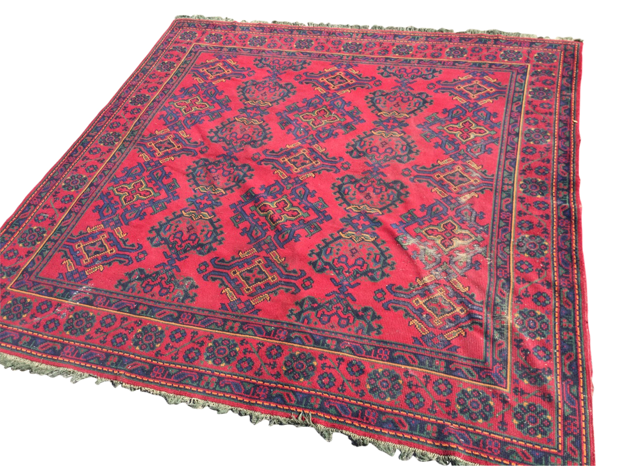 A square Turkey carpet woven in the traditional palette on red ground, the field with rows of