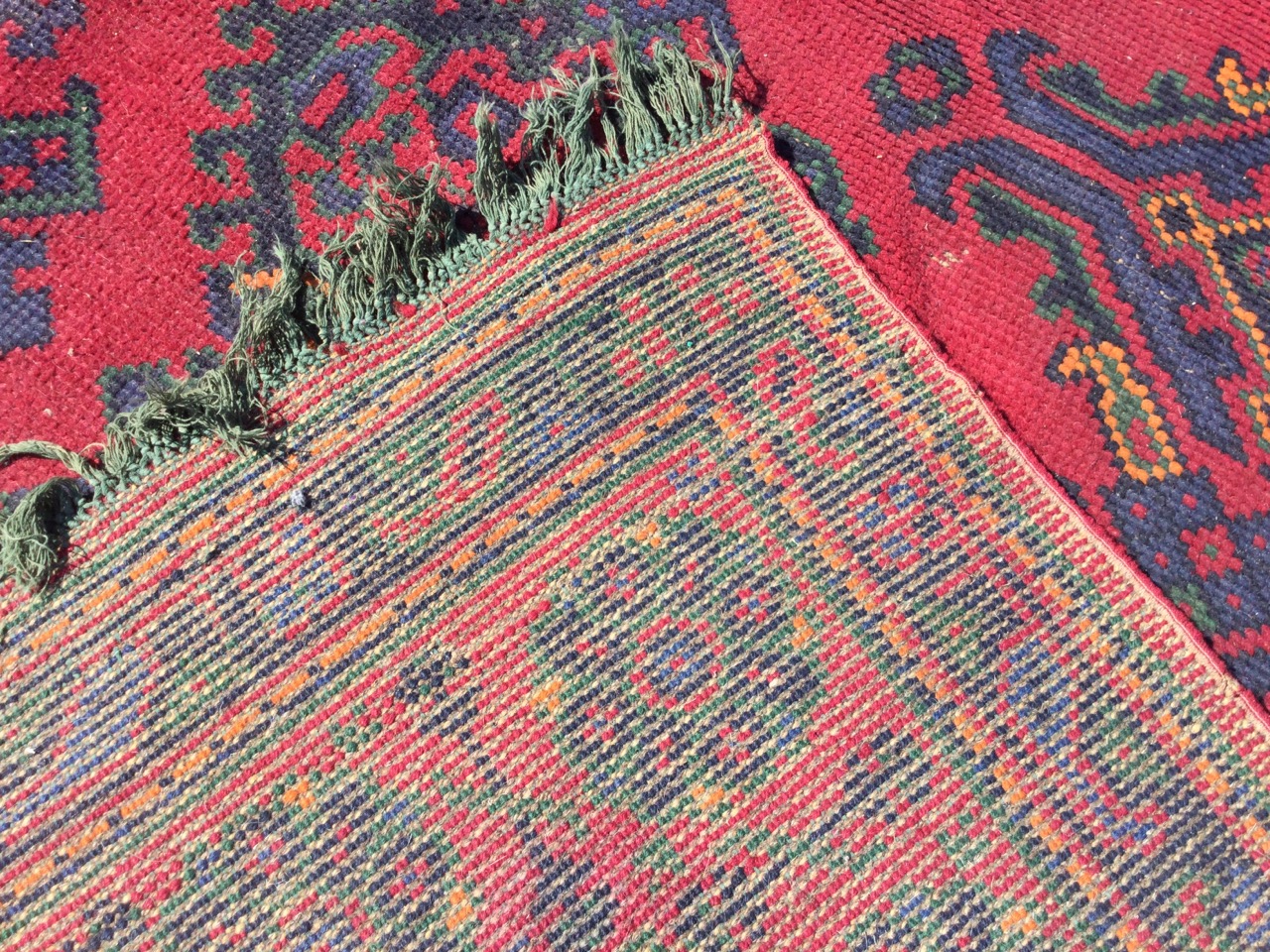 A square Turkey carpet woven in the traditional palette on red ground, the field with rows of - Image 3 of 3