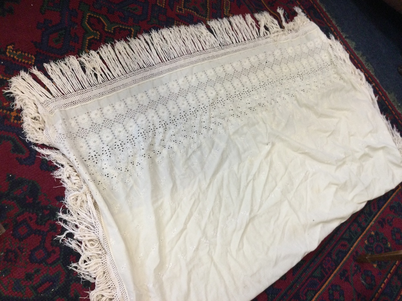 A Victorian cotton shawl embroidered with openwork flowers, having border with crocheted plaited