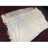 A Victorian cotton shawl embroidered with openwork flowers, having border with crocheted plaited