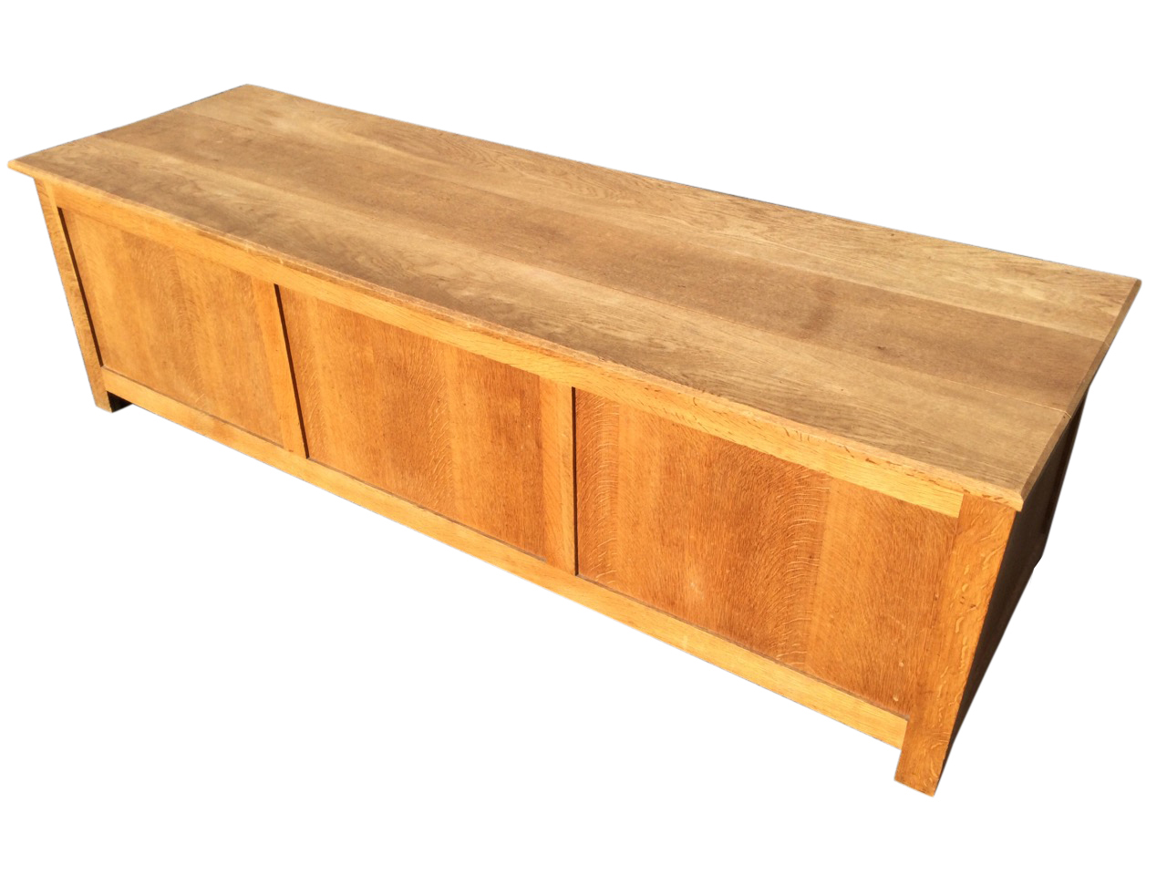A contemporary panelled oak coffer with hinged lid, raised on square bracket feet. (61in x 19in x