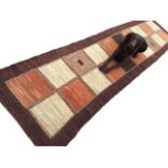 A contemporary Afghan runner woven with 20 square panels within a brown border. (138in x 33.5in)