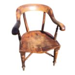 A Victorian smokers bow armchair with shaped back rail above a solid seat, the arms on ring-turned