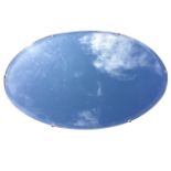 An oval frameless mirror with bevelled plate. (29in x 18.75in)