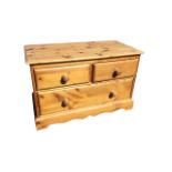 A small pine chest with rectangular moulded top above two short and one long knobbed drawer,