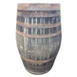 A large oak whiskey barrel, the staves bound by ten riveted metal strap bands. (51in)