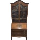 A Queen Anne style mahogany bureau bookcase, the domed moulded cornice above astragal glazed doors