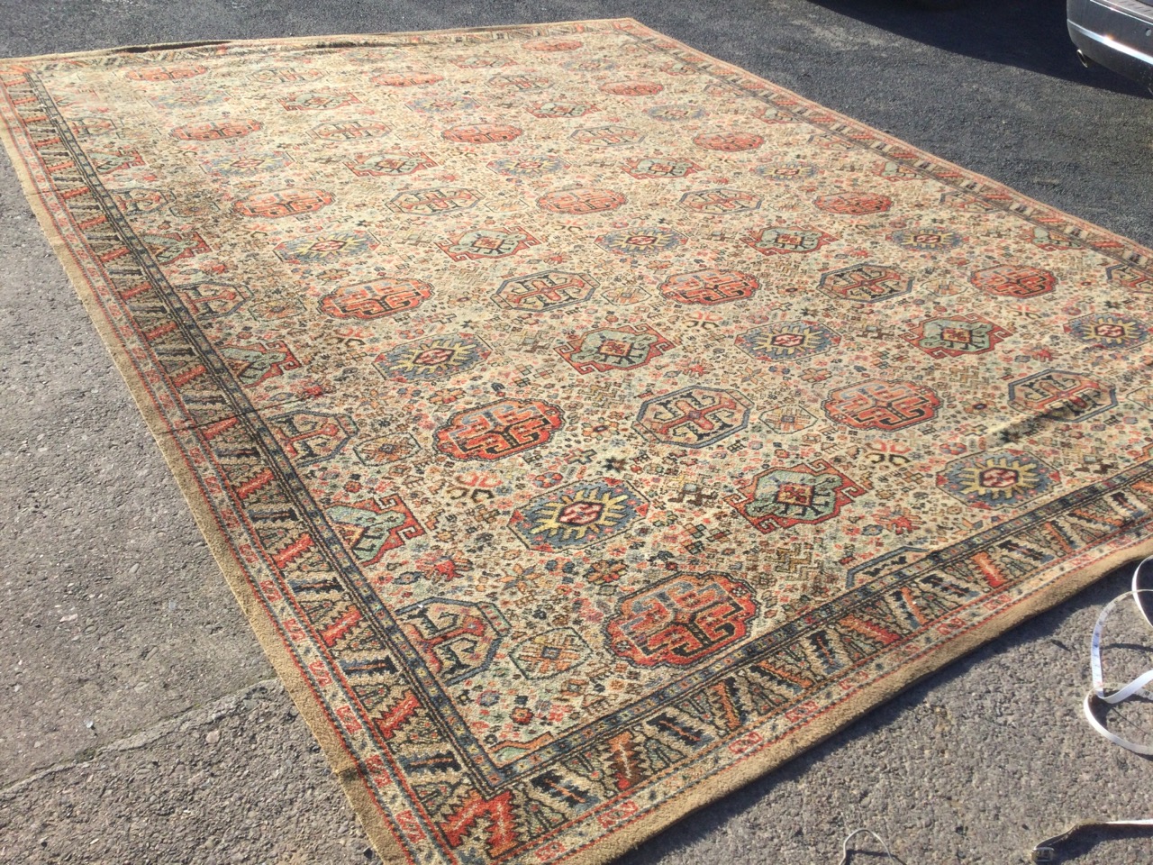 An Axminster carpet woven with field of rectangular octagonal medallions on fawn ground, within a - Image 3 of 3