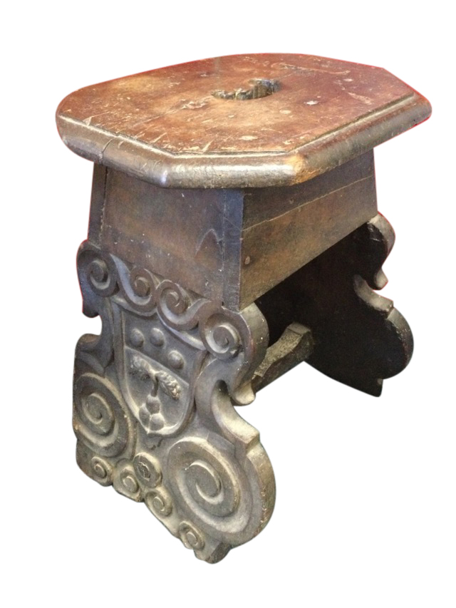 An eighteenth century oak coffin stool, the octagonal top cut with handhold on angled shaped