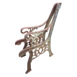 A pair of cast iron bench ends with channelled frames, the moulded arms on scrolled supports with