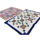 A South African cotton patchwork quilt sewn with colourful panels around square lozenges - 81in x