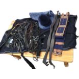 Miscellaneous horse tack including a Christy riding skull cap, a rug roller, breastplates, stirrup