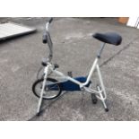 A Terry exercise bicycle on stand with adjustable padded seat and handlebars, having tension dial