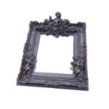 A baroque style rectangular ornate mirror, the foliate scrolled frame mounted with winged putti,