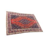 An oriental Indian rug woven with ink blue central medallion and spandrels of trailing flowers