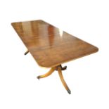 A Georgian style yew twin-pedestal dining table, the top with spare leaf inlaid with stringing,