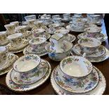 A Wedgwood handpainted floral teaset with birds and bright foliage having brown rims - painted