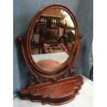 A Victorian mahogany dressing table mirror, the oval plate in cushion moulded frame on scroll carved