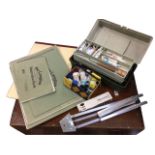 Miscellaneous artists materials including paint boxes, paper sketchbooks, easels, an Italian leather