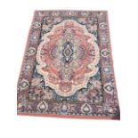 A Belgian belouchi style rug woven with oval scalloped floral field with scrolled spandrels, the