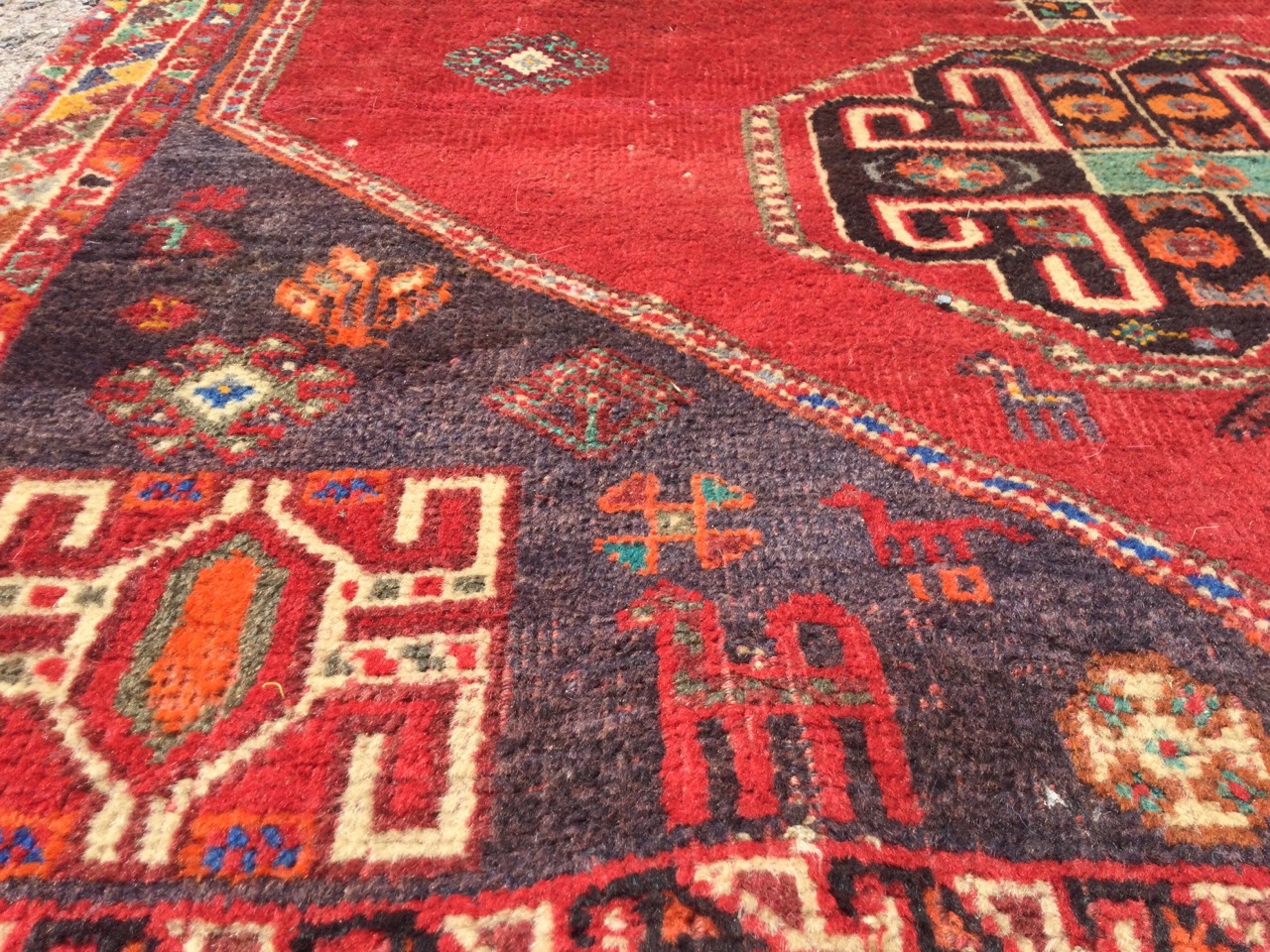 An oriental rug woven with two octagonal hooked medallions on red field having charcoal grey - Image 3 of 3