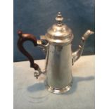 A Georgian style hallmarked silver hotwater jug with hinged domed cover, leaf moulded spout,