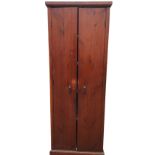 A Victorian tall pine cupboard with moulded cornice above plain doors enclosing shelves, raised on