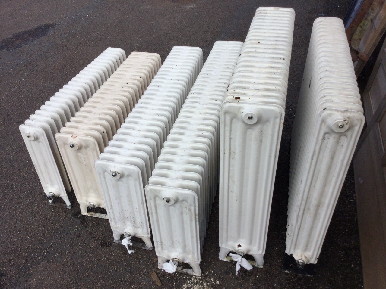 Six miscellaneous cast iron radiators, the panels on angled legs - various heights & lengths, and