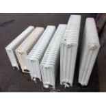 Six miscellaneous cast iron radiators, the panels on angled legs - various heights & lengths, and