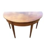 A D-shaped mahogany table, the plain top above a boxwood strung frieze, raised on square tapering
