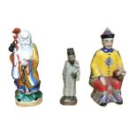 A seated Chinese stoneware figure; a porcelain figure of a bearded immortal in kimono; and a