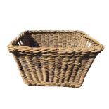 A cane log basket with angled sides, the ends with hand-holes, raised on rectangular batons. (31in x